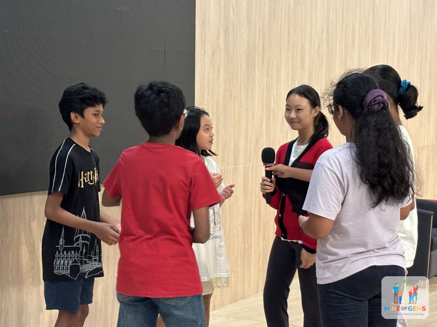 Young people presenting to the group with a microphone