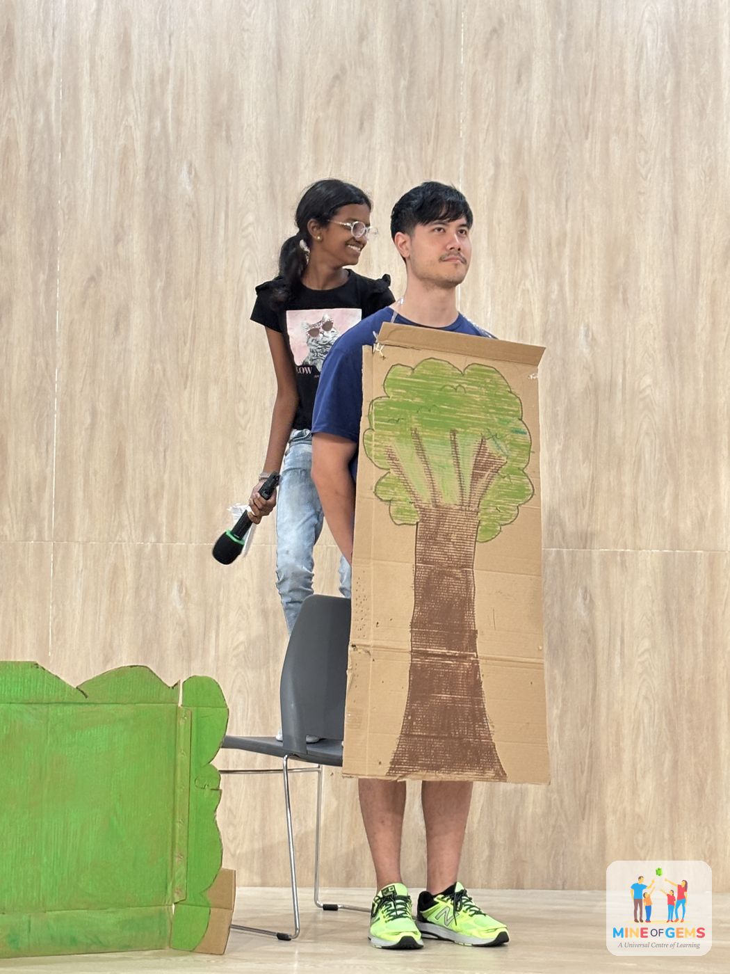 Youths acting out a short play with a painted tree