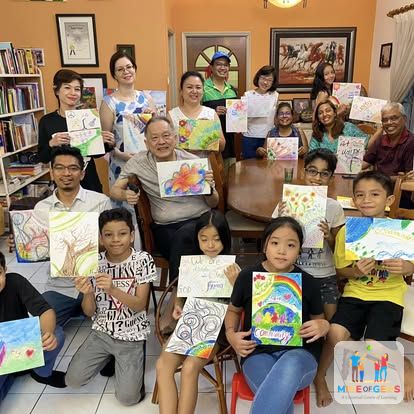 A group of children and adults showing their artwork