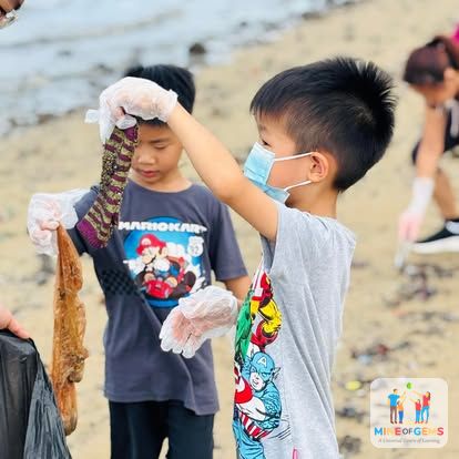Boys picking up rubbish on a beach