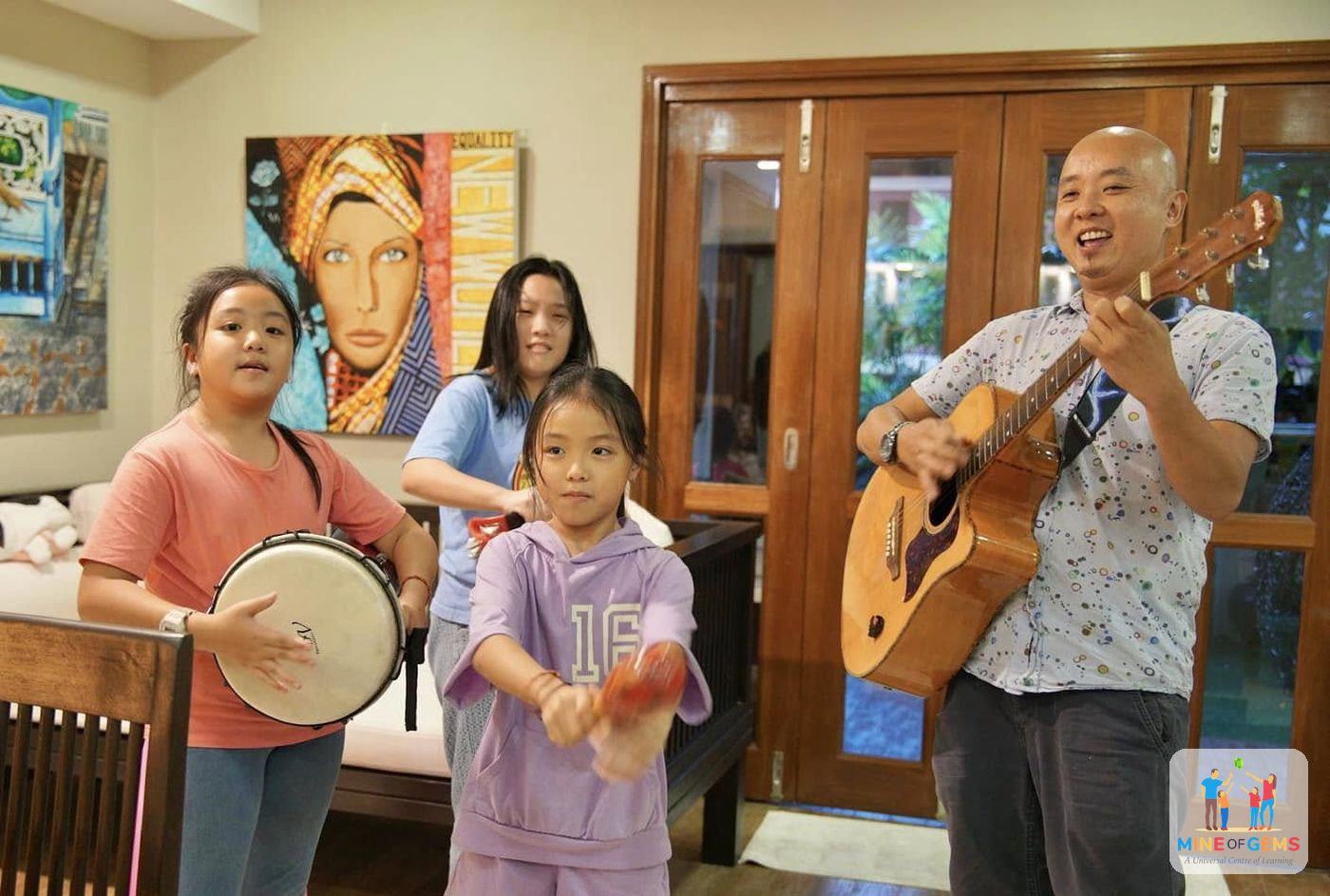 Greg playing guitar with children in a music session