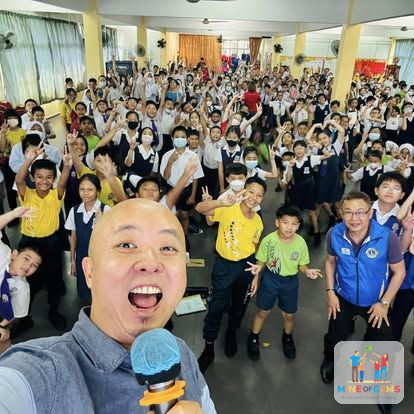 Greg with a large group of cheering school children