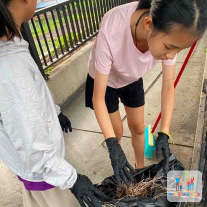 A young volunteer cleaning up with gloves