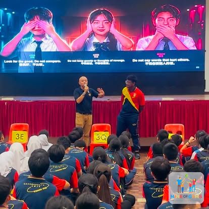 Greg and a student on stage in front of an audience